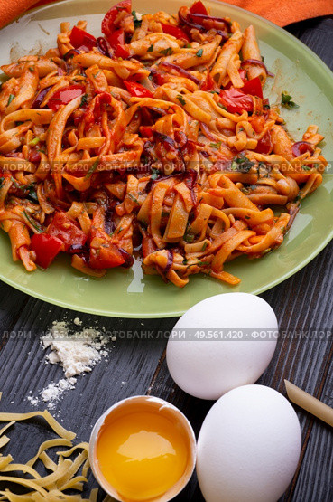  italian pasta with tomatos and herbs on dark wooden table. italian pasta recipe.  . Стоковое фото, агентство Ingram Publishing / Фотобанк Лори