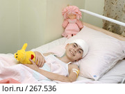 Девочка с перевязанной головой лежит в кровати с игрушкой в руке. Детская больница (2004 год). Редакционное фото, фотограф Виктор Филиппович Погонцев / Фотобанк Лори