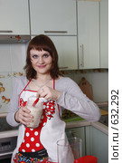Молодая хозяйка кладет в стеклянную банку с рисовой крупой стручок жгучего перца. Стоковое фото, фотограф Ирина Карлова / Фотобанк Лори