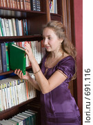 Девушка кладет книгу на полку (2008 год). Редакционное фото, фотограф Донцов Евгений Викторович / Фотобанк Лори
