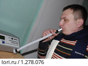 Проверка на алкоголь. Мужчина дует в трубочку алкометра (2009 год). Редакционное фото, фотограф Александр Легкий / Фотобанк Лори