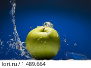 Зеленое яблоко с всплеском воды на синем фоне. Стоковое фото, фотограф Ярослав Данильченко / Фотобанк Лори