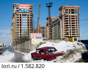 Старая разломанная машина на фоне новостроек. Социальный контраст (2010 год). Редакционное фото, фотограф Jumbo / Фотобанк Лори