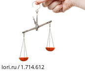 Неуравновешенные чаши лабораторных или медицинских весов в руке, изолированные на белом фоне. Стоковое фото, фотограф Илья Андриянов / Фотобанк Лори