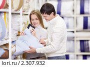 Молодая замужняя пара выбирает подушку в магазине. Стоковое фото, фотограф Raev Denis / Фотобанк Лори
