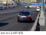 Автомобиль с синим спецсигналом едет по дороге в центре Москвы (2011 год). Редакционное фото, фотограф Яна Королёва / Фотобанк Лори