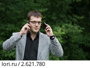Бизнесмен говорит по двум мобильным телефонам. Стоковое фото, фотограф Ольга Герасимова / Фотобанк Лори