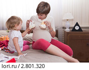 Беременная с дочкой подбирают одежду. Стоковое фото, фотограф Кристина Викулова / Фотобанк Лори