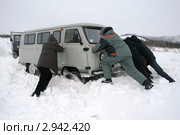 Мужчины выталкивают машину из снега (2009 год). Редакционное фото, фотограф Алена Потапова / Фотобанк Лори