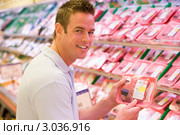 Мужчина держит упаковку свежезамороженного мяса в магазине. Стоковое фото, фотограф Monkey Business Images / Фотобанк Лори