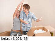 Пара дурачится, распаковывая вещи после переезда. Стоковое фото, фотограф CandyBox Images / Фотобанк Лори