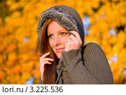 Рыжеволосая девушка с рыжими волосами кутается в коричневую кофту с капюшоном на фоне осенней природы. Стоковое фото, фотограф CandyBox Images / Фотобанк Лори