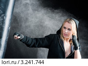 Девушка-боксер в капюшоне бьёт грушу. Стоковое фото, фотограф CandyBox Images / Фотобанк Лори