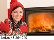 Молодая женщина в вязаной шапке и перчатках согревается у камина (крупный план) Стоковое фото, фотограф CandyBox Images / Фотобанк Лори