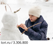 Девочка подросток строит снеговика. Стоковое фото, фотограф Игорь Низов / Фотобанк Лори
