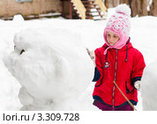Маленькая девочка аккуратно строит снеговика (2012 год). Редакционное фото, фотограф Игорь Низов / Фотобанк Лори