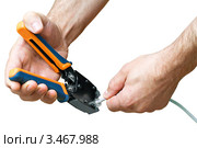 Инструмент для опрессовки разъемов RJ45 в руках человека, белый фон. Стоковое фото, фотограф Юрий Плющев / Фотобанк Лори