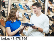 Девушка-продавец предлагает мужчине обувь в магазине. Стоковое фото, фотограф Дмитрий Калиновский / Фотобанк Лори
