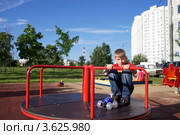 Ребенок на карусели на деткой площадке во дворе (2012 год). Редакционное фото, фотограф Яна Королёва / Фотобанк Лори