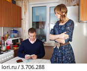 Финансовые проблемы. Жена смотрит на мужа, считающего деньги. Стоковое фото, фотограф Яков Филимонов / Фотобанк Лори