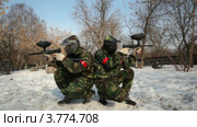 Два игрока в пейнтбол сидят с оружием в руках спина к спине. Стоковое видео, видеограф Losevsky Pavel / Фотобанк Лори