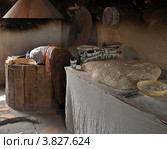 Грузия, пекарня, женщина достает длинный грузинский хлеб из большой, круглой, глиняной печи тонэ (2012 год). Редакционное фото, фотограф Светлана Васильева / Фотобанк Лори