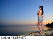 Девушка в джинсовых шортах на берегу моря на закате. Стоковое фото, фотограф Арестов Андрей Павлович / Фотобанк Лори