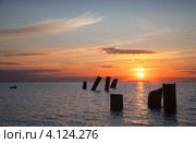 Закат над морем, оранжевое небо, столбы разрушенного пирса. Стоковое фото, фотограф EugeneSergeev / Фотобанк Лори