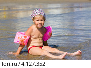 Трехлетняя девочка сидит в воде на морском берегу (2012 год). Редакционное фото, фотограф Катерина Макарова / Фотобанк Лори