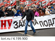 Сергей Удальцов топчет ногами, разорванный перед этим, листок бумаги с портретом человека похожего на Владимира Путина на "Марше против подлецов" в Москве (2013 год). Редакционное фото, фотограф Николай Винокуров / Фотобанк Лори