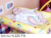 Четырехмесячный малыш лежит на доске для пеленания (2013 год). Редакционное фото, фотограф ivolodina / Фотобанк Лори