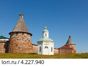 Белая часовня на фоне каменной крепостной стены и башни православного монастыря в Соловках летом (2011 год). Редакционное фото, фотограф Ольга Липунова / Фотобанк Лори