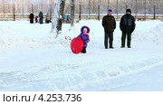 Радостный ребенок на ледянке скатывается с ледяной горки (2013 год). Редакционное видео, видеограф Юлия Машкова / Фотобанк Лори