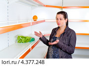 Молодая женщина рядом с пустыми полками в магазине. Стоковое фото, фотограф Юлия Гапеенко / Фотобанк Лори