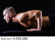 Мускулистый мужчина отжимается на темном фоне. Стоковое фото, фотограф Elnur / Фотобанк Лори