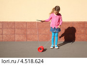 Маленькая девочка играет с йо-йо на улице. Стоковое фото, фотограф Losevsky Pavel / Фотобанк Лори
