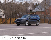 Кроссовер FORD с бочкой на багажнике мчится по загородной дороге (2013 год). Редакционное фото, фотограф Павел Кричевцов / Фотобанк Лори