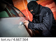 Автомобильный вор вскрывает дверь у машины. Стоковое фото, фотограф Андрей Армягов / Фотобанк Лори