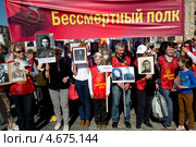 Москвичи держат портреты своих дедушек и прадедушек, воевавших на войне, на акции памяти "Бессмертный полк" в парке Победы на Поклонной горе города Москвы (2013 год). Редакционное фото, фотограф Николай Винокуров / Фотобанк Лори