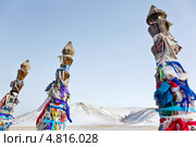 Крупным планом ленточки привязанные на столбики коновязи (Сэргэ) с привязанными лентами залаа на месте поклонения богу Бурхану по дороге к озеру Байкал. Стоковое фото, фотограф Николай Винокуров / Фотобанк Лори
