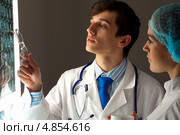 Коллеги-врачи у светящегося экрана с томографическими снимками больного. Стоковое фото, фотограф Sergey Nivens / Фотобанк Лори