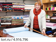 Продавец отмеряет кусок ткани в магазине. Стоковое фото, фотограф Яков Филимонов / Фотобанк Лори