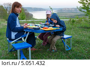 Семья за раскладным столом обедает на природе. Стоковое фото, фотограф Юрий Брыкайло / Фотобанк Лори
