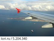Крыло самолета пролетающего над морем. Стоковое фото, фотограф Михаил Коханчиков / Фотобанк Лори