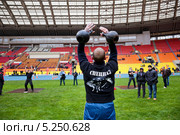 Сотрудник полицейского спецназа участвует в соревнованиях по гиревому спорту в День московской полиции на стадионе "Лужники" в Москве (2013 год). Редакционное фото, фотограф Николай Винокуров / Фотобанк Лори