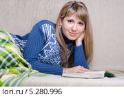 Девушка читает книгу, накрывшись пледом на диване. Стоковое фото, фотограф Иванов Алексей / Фотобанк Лори