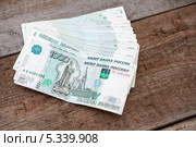 Стопка тысячных банкнот на деревянном полу. Стоковое фото, фотограф Кекяляйнен Андрей / Фотобанк Лори