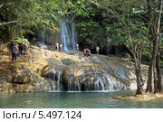 Туристы на фоне водопада Сайок Ной (Sai Yok Waterfall). Национальный парк Сай Йок, Канчанабури, Королевство Таиланд (2013 год). Редакционное фото, фотограф Григорий Писоцкий / Фотобанк Лори