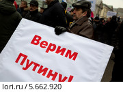 Мужчина с баннером "Верим Путину!" на шествии в поддержку соотечественников на Украине, Москва (2014 год). Редакционное фото, фотограф Николай Винокуров / Фотобанк Лори