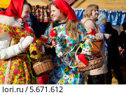 Молодые красивые девушки продают куклы Масленицы на праздных гуляньях в Коломенском города Москвы, Россия (2014 год). Редакционное фото, фотограф Николай Винокуров / Фотобанк Лори